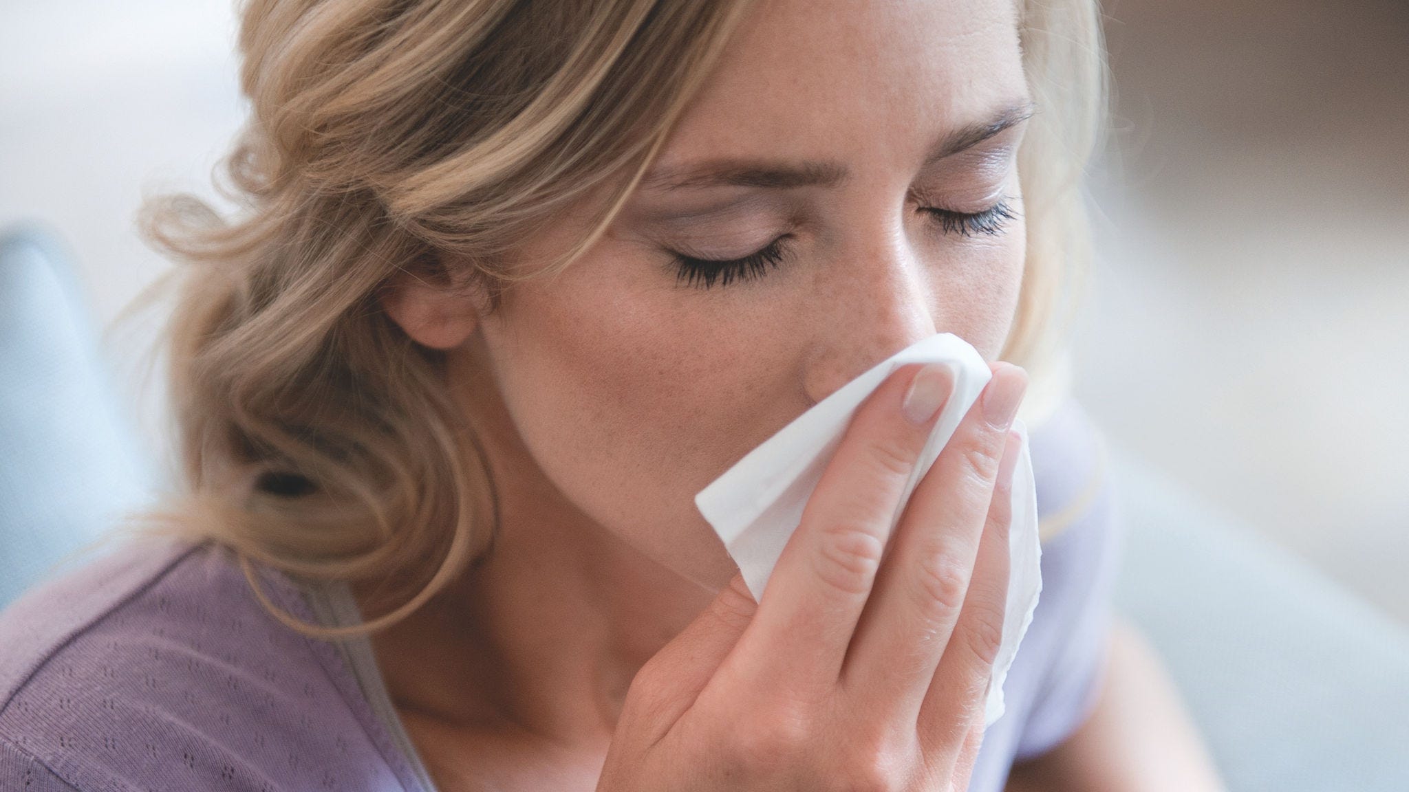 Ženska, ki si briše nos zaradi alergije na pelod