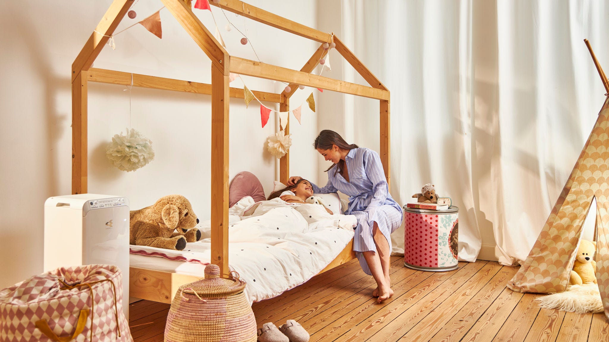 Mama daje otroka spat v zdravem domu zaradi čistilnika zraka Daikin v otroški sobi