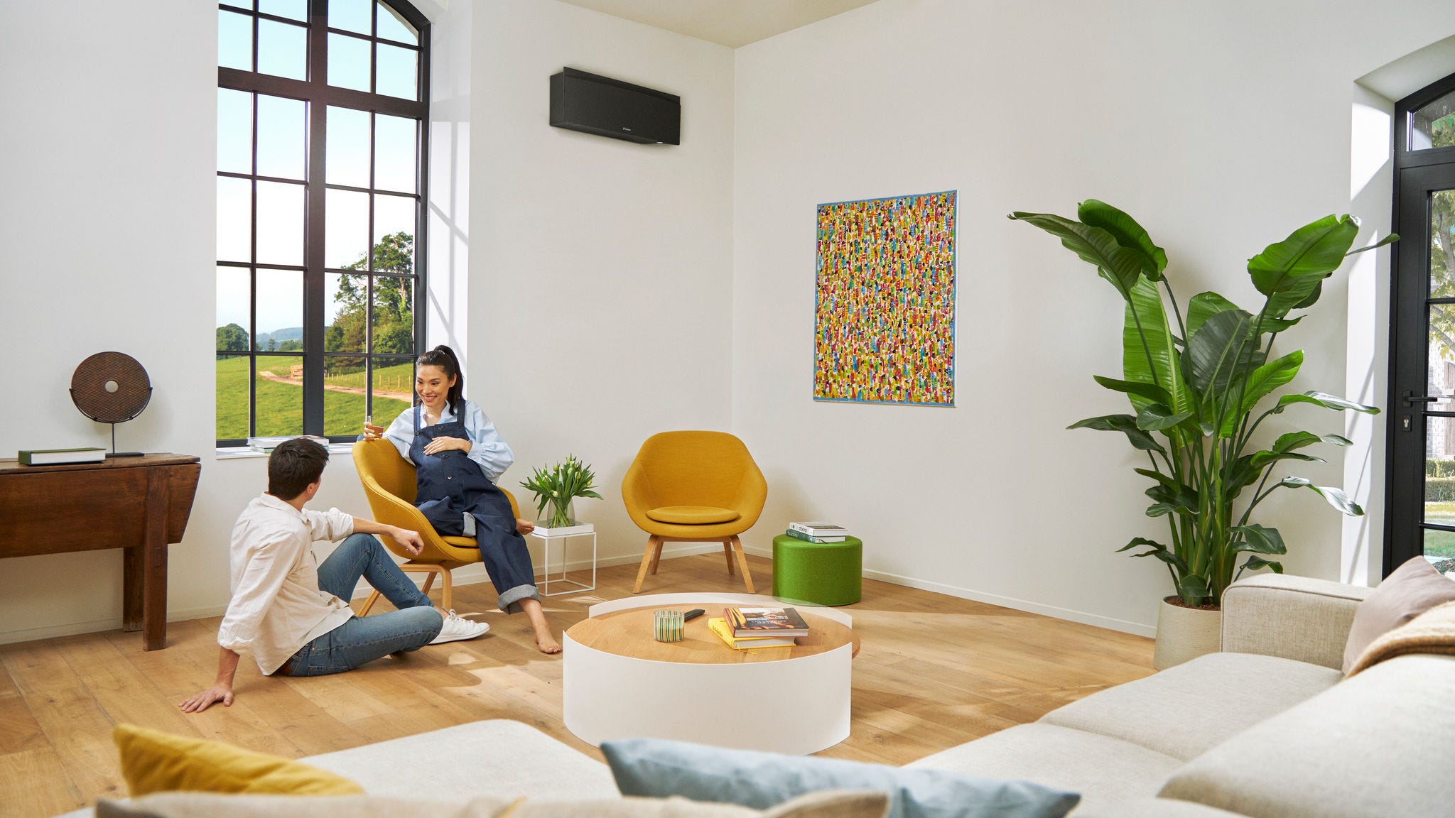 Noseč par se sproščeno pogovarja, ko ženska sedi na stolu