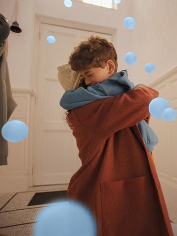 Mati in sin se toplo objemata v elegantnem ter mirnem bivalnem prostoru, kjer uživata v kot šepet tihem udobju toplotne črpalke zrak–zrak Daikin