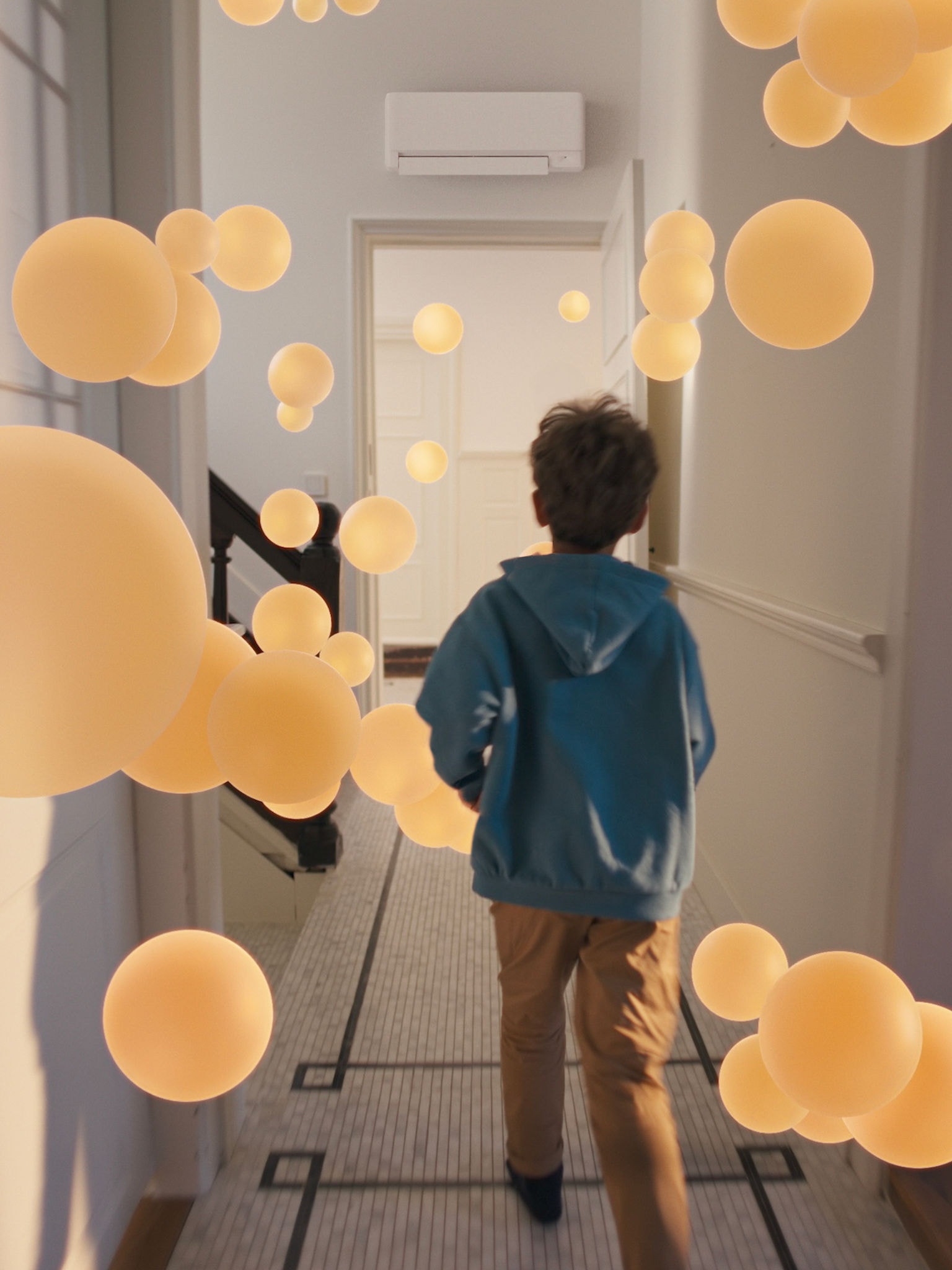 Deček se sprehaja po hodniku z enakomernim in uravnoteženim pretokom zraka, ki ga omogoča dobro zasnovan sistem s toplotno črpalko zrak–zrak