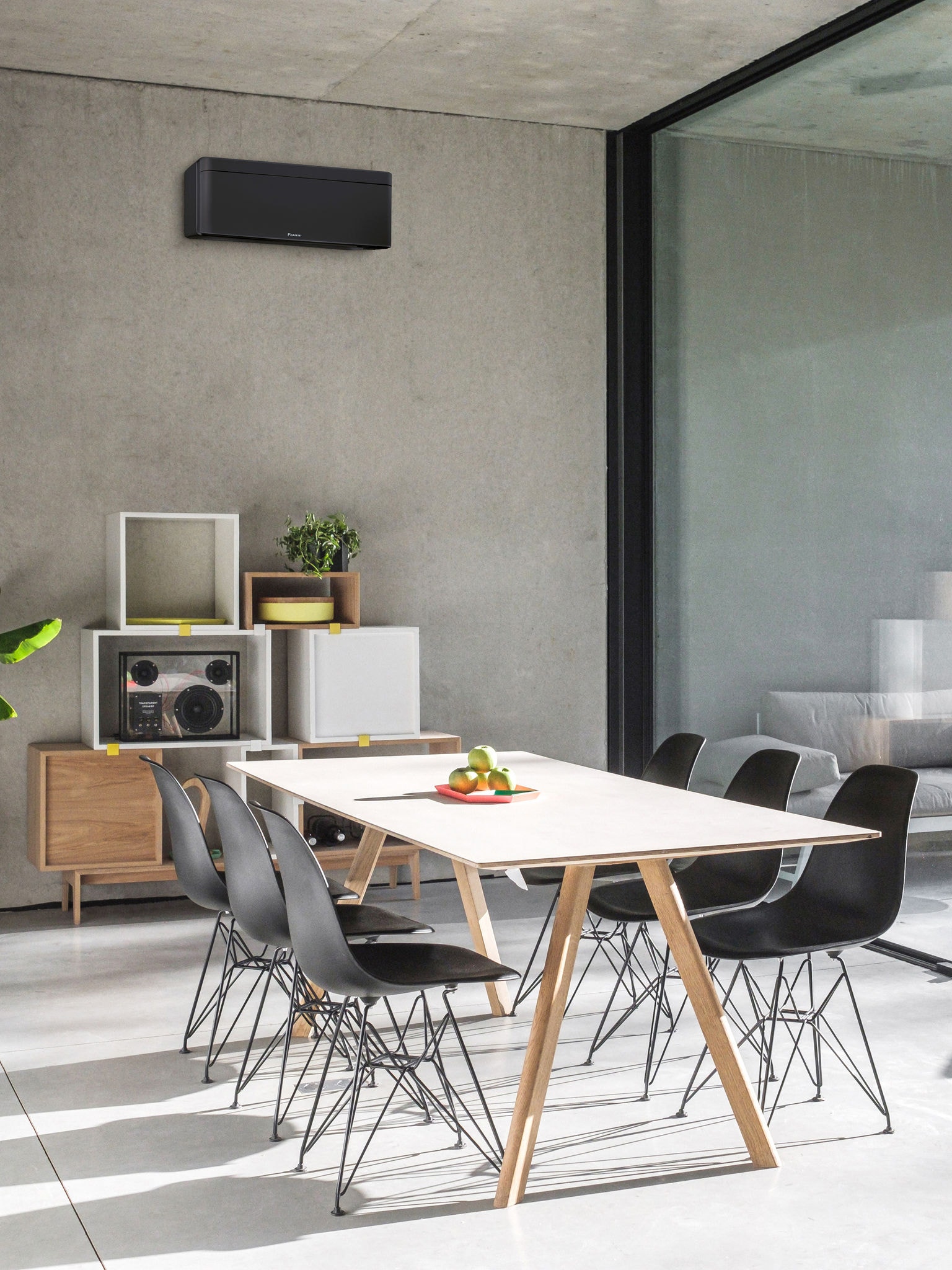 Jedilnica z velikim oknom in stensko notranjo enoto toplotne črpalke zrak–zrak