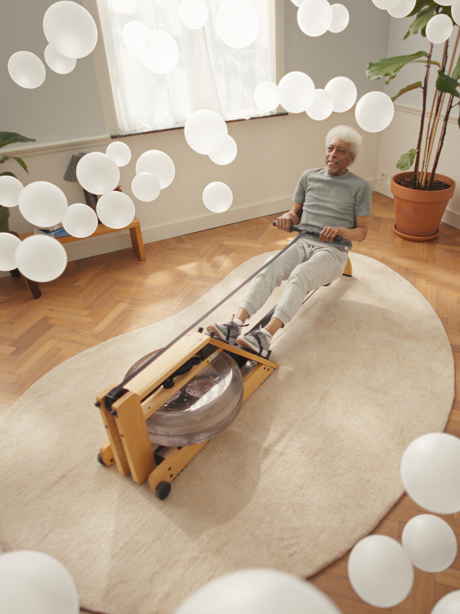 Starejši moški telovadi na veslaški napravi v okolju s čistim zrakom