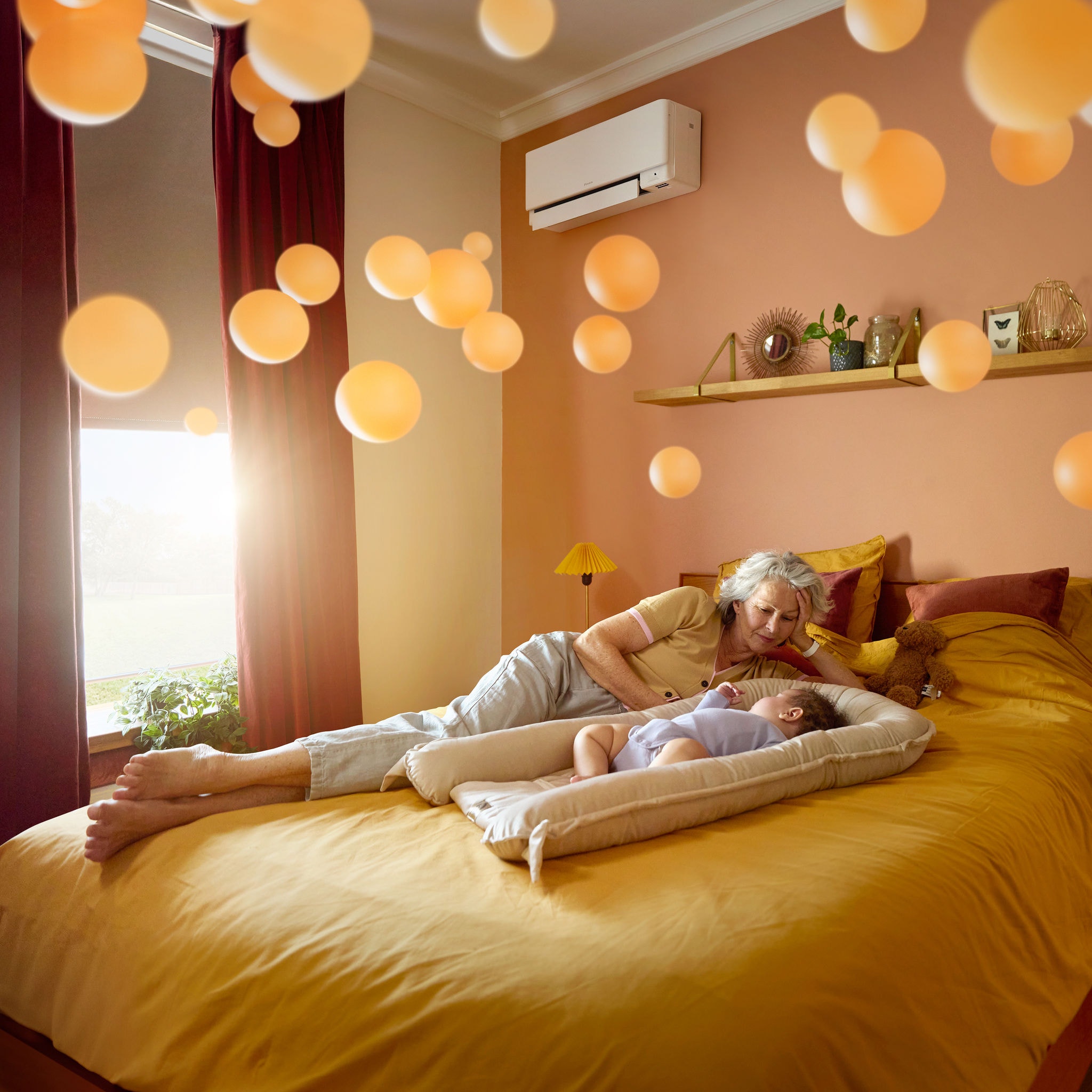 Babica leži ob mirno spečem otroku v mirni in udobno ogrevani sobi po zaslugi tihe toplotne črpalke zrak–zrak