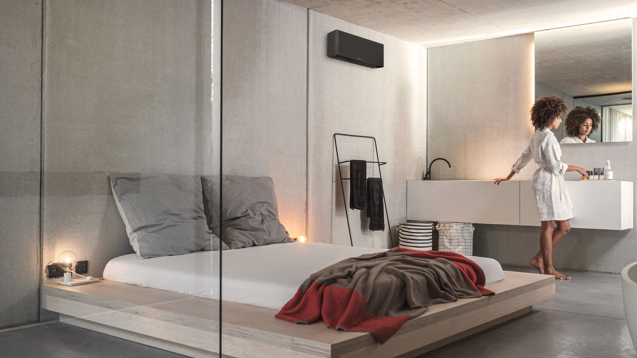 Ženska v spalnici s stilsko klimatsko napravo Daikin